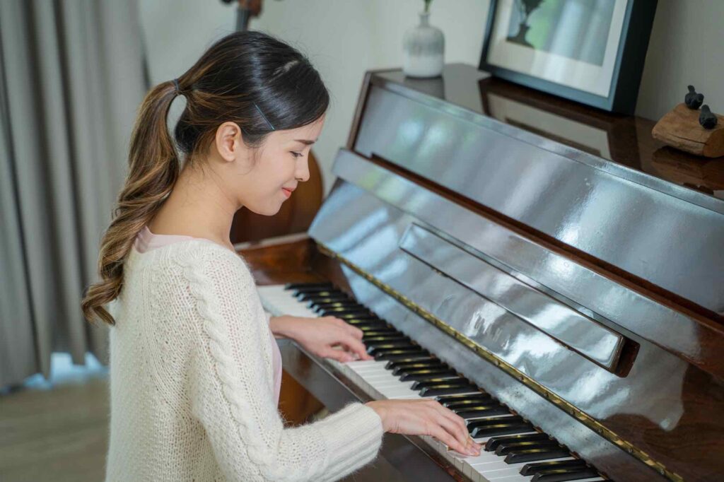 Asian women pianist is enjoying playing piano in the studio.