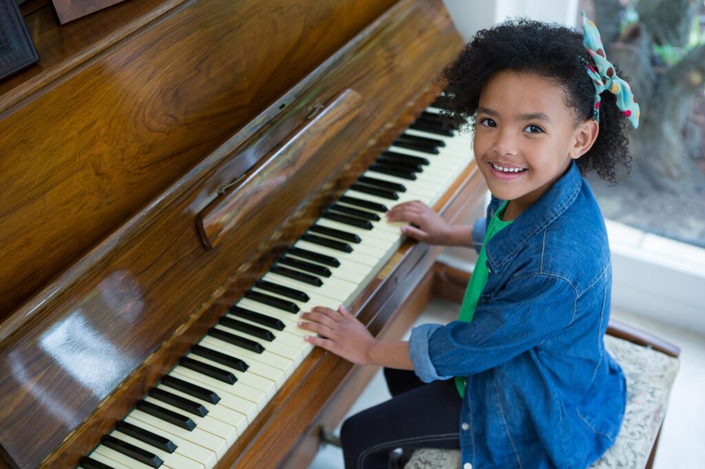 Adorable girl playing piano